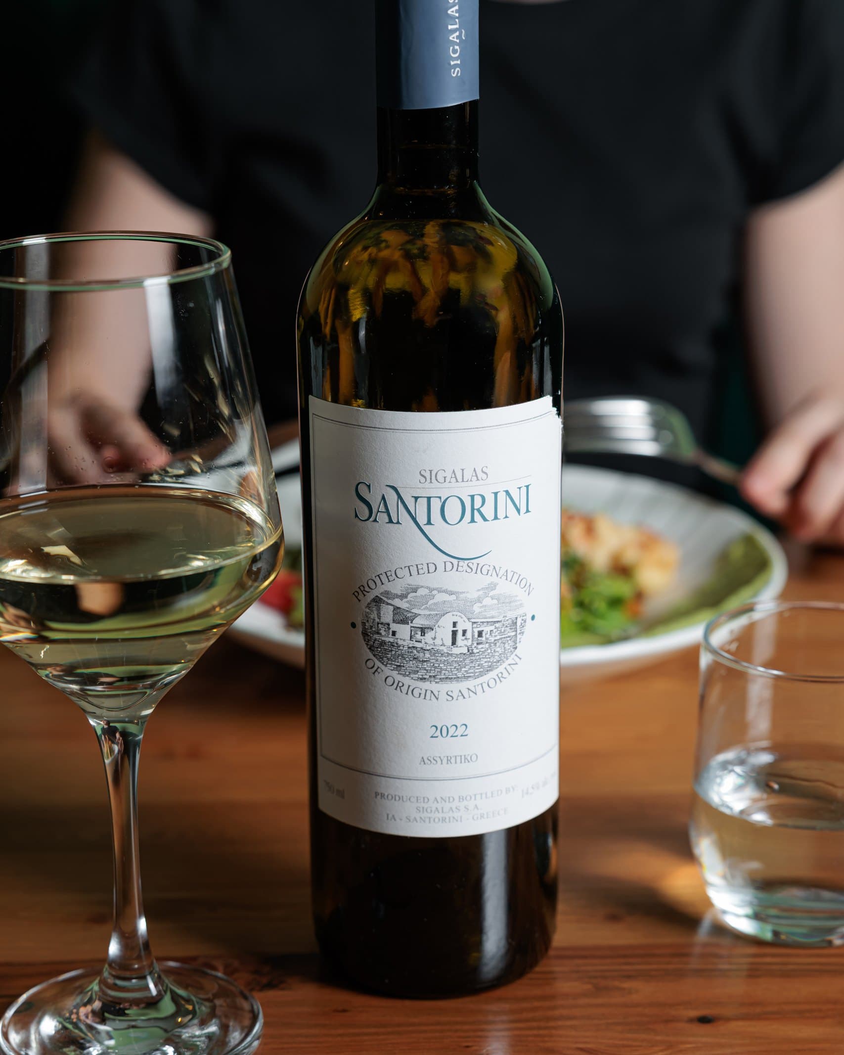 A bottle and glass of white wine on the table