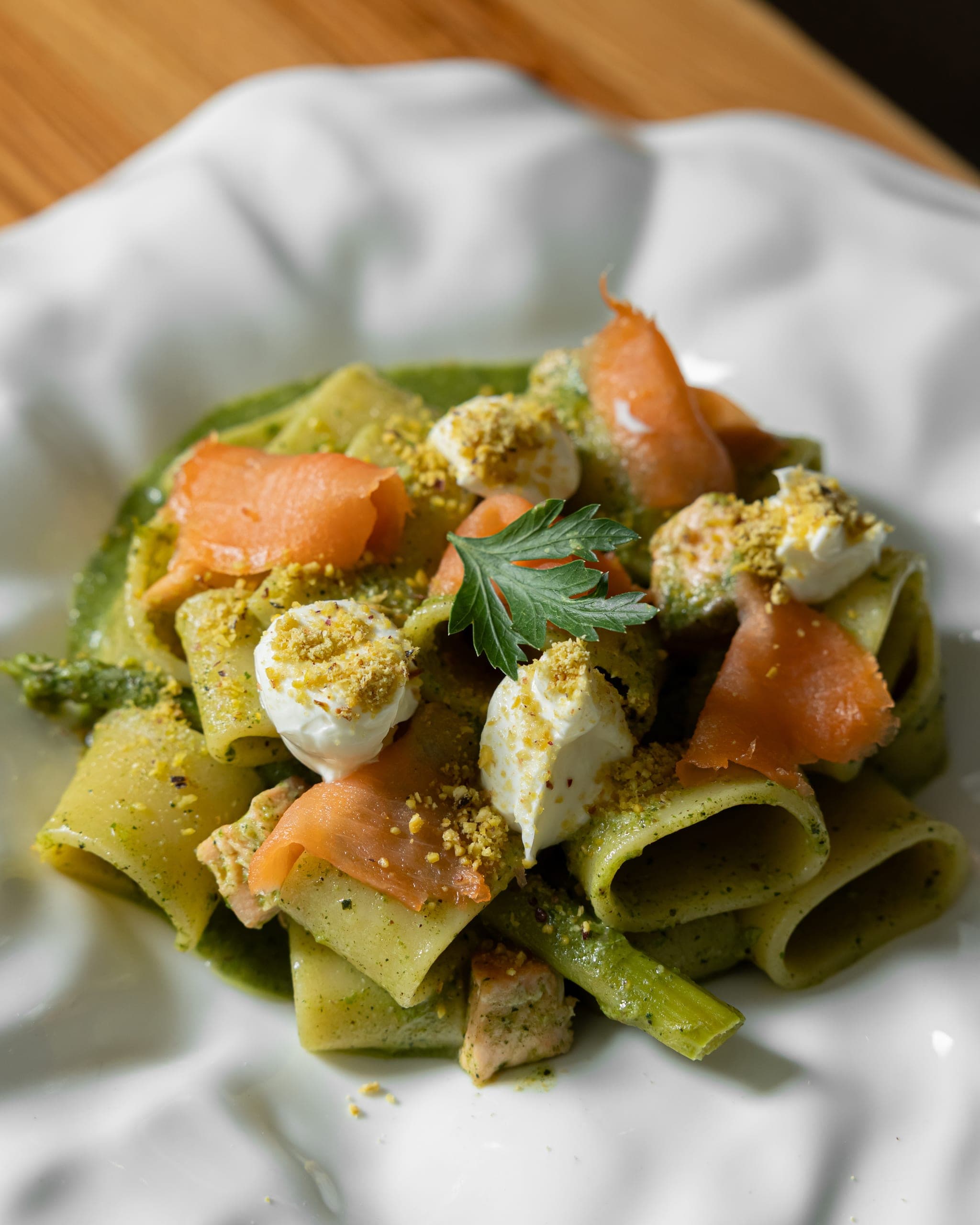 Spinach pasta with smoked salmon, creamy cheese and crushed pistachio